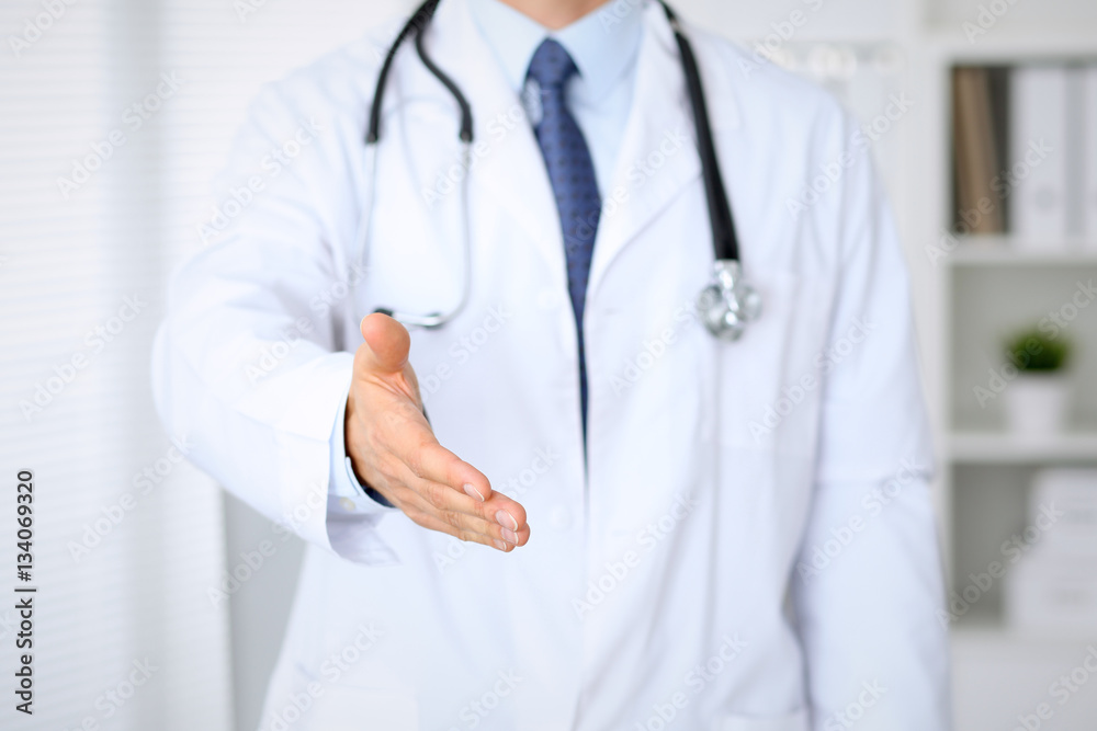 Male medicine doctor offering helping hand for handshake. Partnership and trust concept. Male medicine doctor offering helping hand for handshake. Partnership and trust concept.