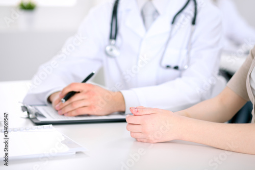 Doctor and patient are discussing something  just hands at the table