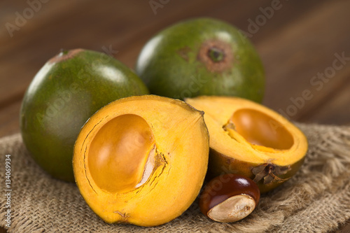 Peruvian fruit called Lucuma (lat. Pouteria lucuma), which is widely used in Peru as a food ingredient (Selective Focus, Focus on the standing lucuma half)