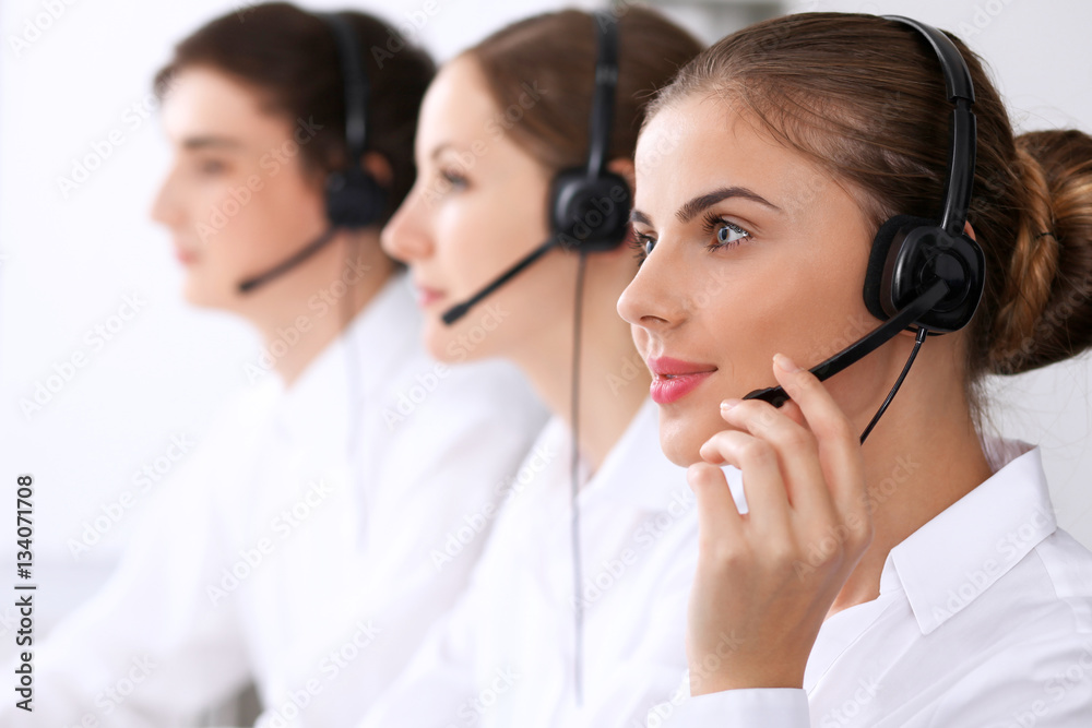 Call center. Focus on beautiful woman in headset Call center. Focus on beautiful woman in headset