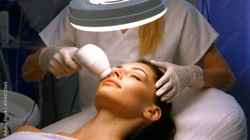 Doctor giving facial massage through soniclifting Doctor giving facial massage through soniclifting