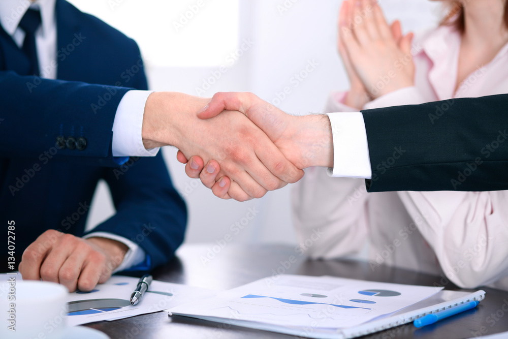 Business people shaking hands finishing up a meeting Business people shaking hands finishing up a meeting