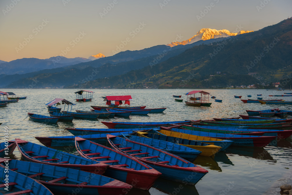 Sunrise with wooden boats on Phewa lake, Pokhara, Nepal.