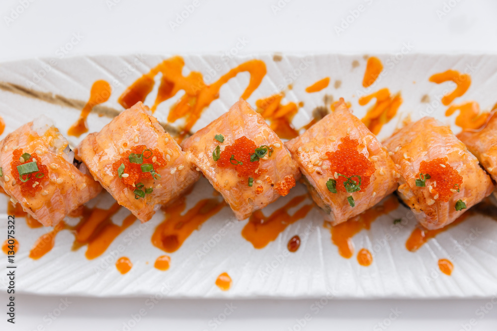 Torched Salmon Maki Sushi with Shrimp Tempura, Avocado and Cheese inside. Topping with Sauce, Ebiko (Shrimp Egg) and Scallion. Torched Salmon Maki Sushi with Shrimp Tempura, Avocado and Cheese inside. Topping with Sauce, Ebiko (Shrimp Egg) and Scallion.