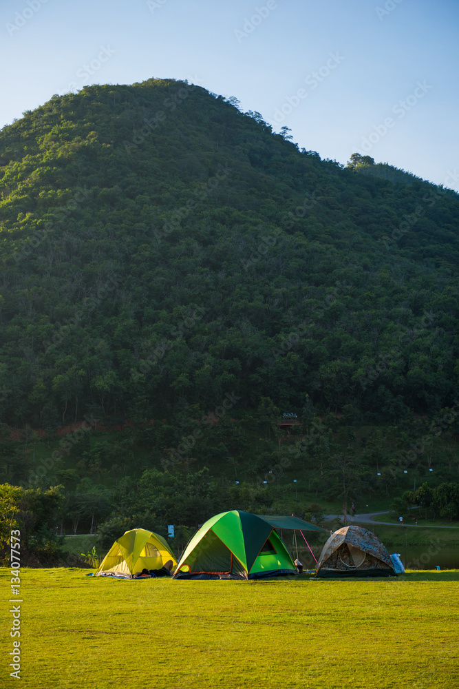 Tents camping on grass field beside the river