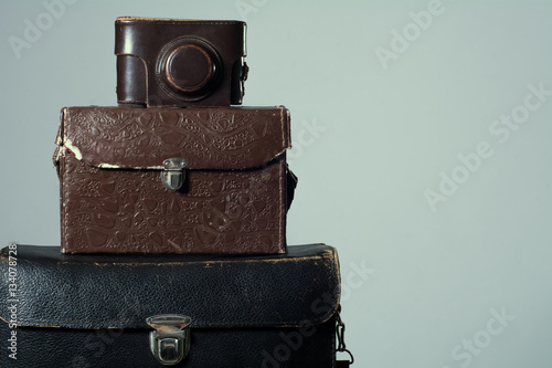 Background stack of old shabby suitcase with a camera in bag.