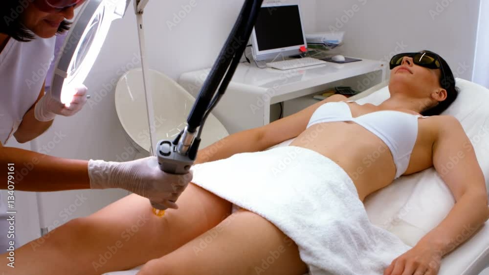 Doctor performing laser hair removal on patient skin