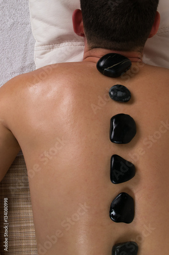 relaxing massage with warm stones male on spa treatments