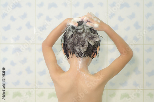 child n shower washing hair with shampoo