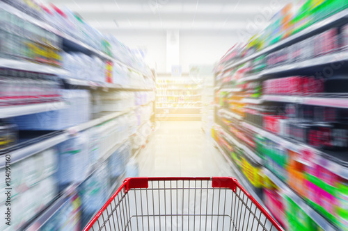 Supermarket aisle with empty red shopping cart