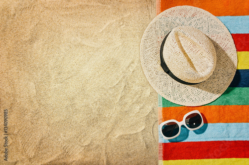 Photos Top view of sandy beach with towel frame and summer accessories