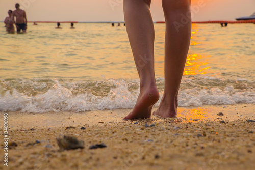 leg barefoot going to sea with sunset time