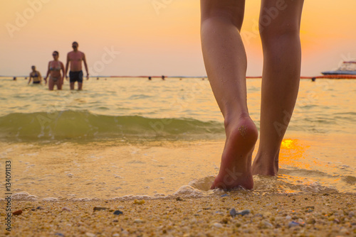 leg barefoot going to sea with sunset time