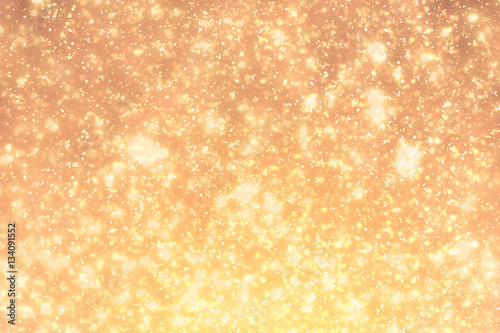 Golden sparkles or glitter lights. Festive gold background. Defocused circles bokeh or particles