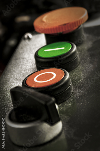 Dusty button console of an industrial machinery (including power ON/OFF and emergency stop buttons).