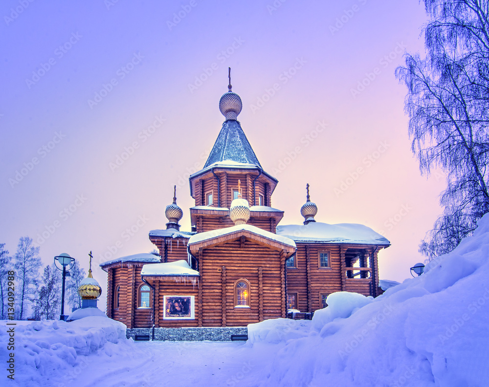 Frosty winter morning with old rural wooden chapel and colorful