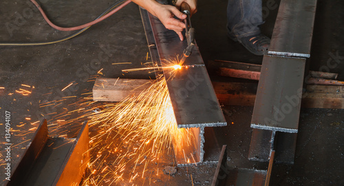 Metal cutter, steel cutting with acetylene torch, industrial worker on manufacturing area.