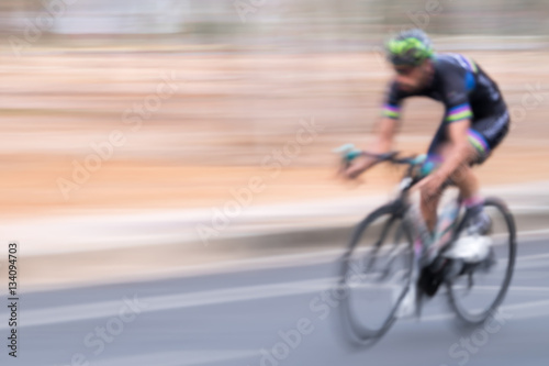 Blurred background of a man riding bicycle.
