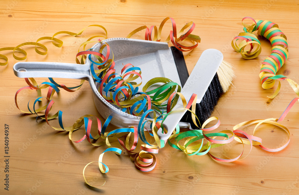 Obraz premium Handfeger kehrt Luftschlangen auf die Kehrschaufel