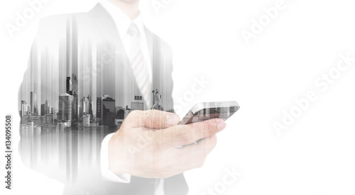 Double exposure businessman using smartphone with city, business network communication technology 