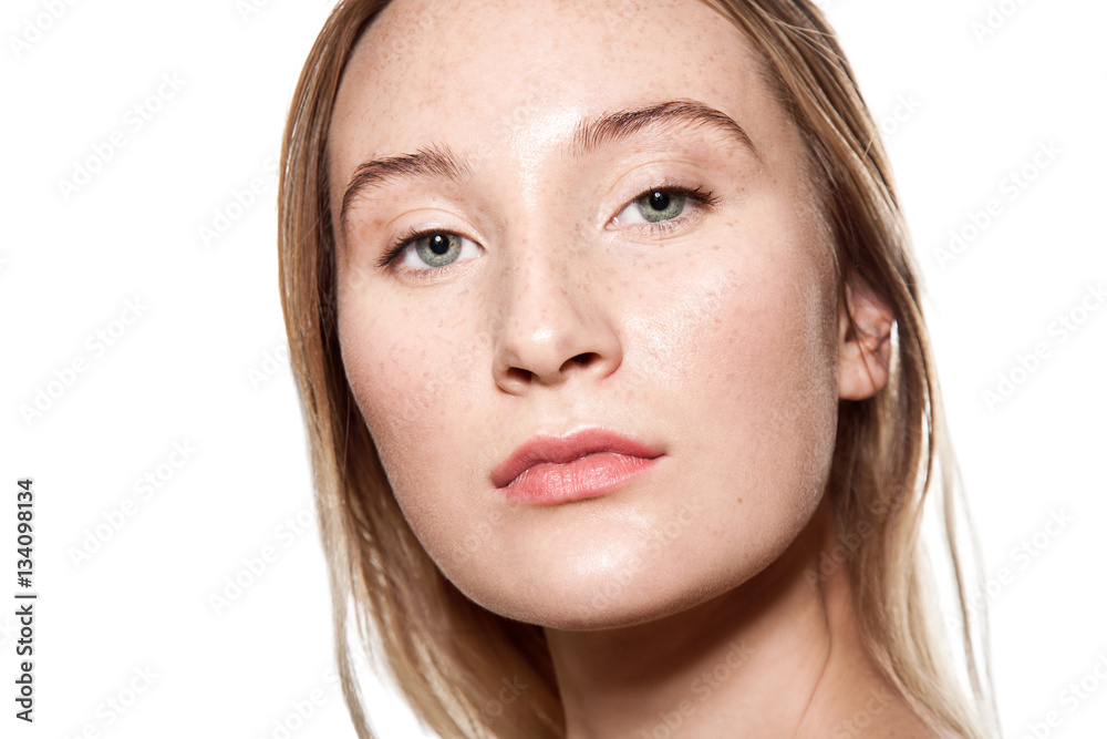 Beautiful woman with freckles on her face and body, with light sensitive skin. Close up portrait on a white background Beautiful woman with freckles on her face and body, with light sensitive skin. Close up portrait on a white background