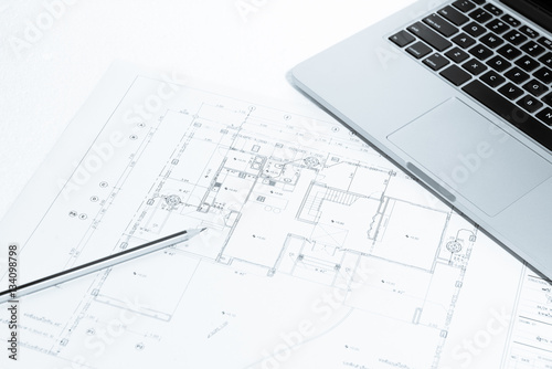 Pen, and notebook over house construction blueprint with blue to