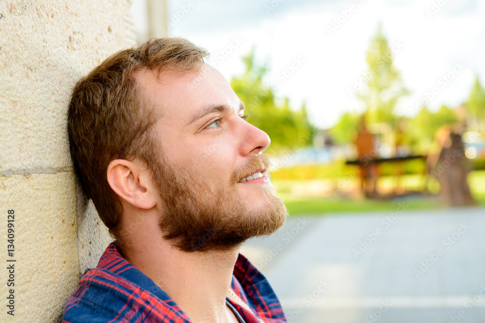 bearded man lean on wall and looking rexaxed bearded man lean on wall and looking rexaxed
