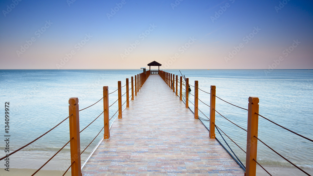 Beautiful sunset over wooden jetty with silhoutte of man fishing Beautiful sunset over wooden jetty with silhoutte of man fishing