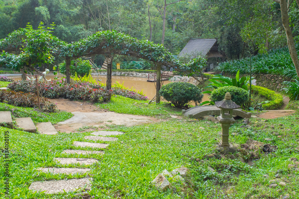 Asian tranquil garden with stone path, pond with beautiful landscape design