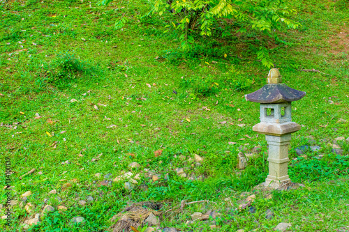 Asian traditional lamp in a garden with lush lawn © Anastasiia