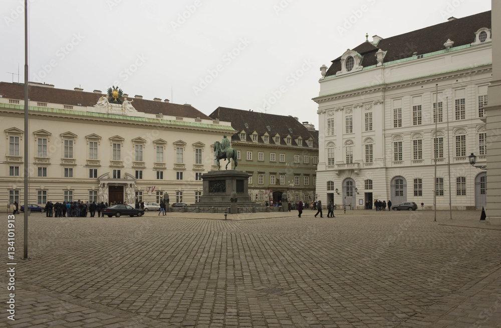 Inside Hofburg complex in Vienna, square with equestrian statue and people around