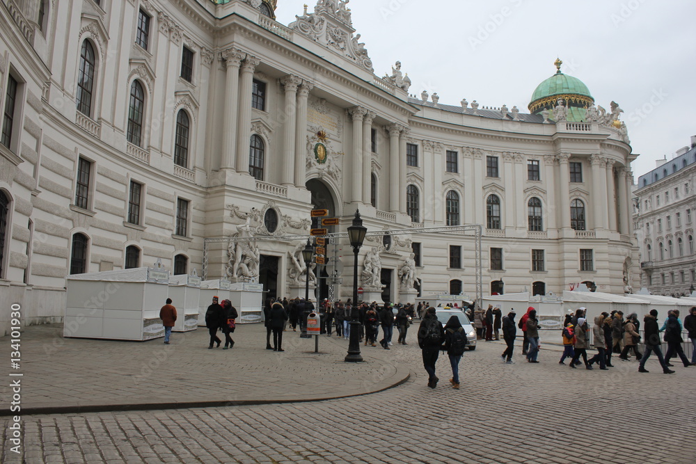 Michaelerplatz square in Vienna at day time, facing the Hofburg complet entrance and people around