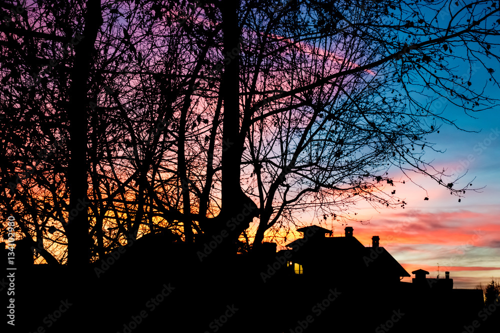 Colorful epic sunset and house and tree silhouette Colorful epic sunset and house and tree silhouette