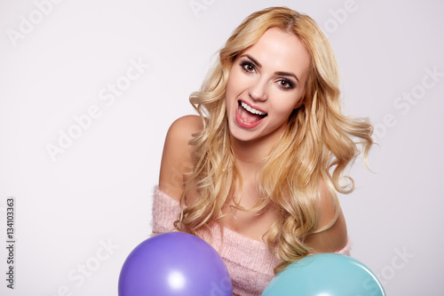 Young beautiful blonde girl holding balloons