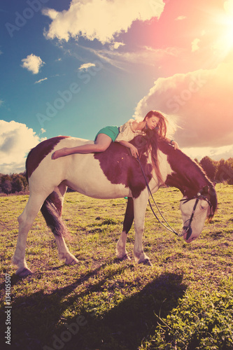 Beautiful woman with a horse in the field. Girl on a farm with a © Miramiska