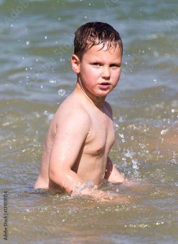 boy is bathed in the lake to the beach