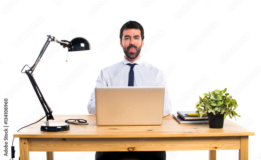 Businessman in his office taking out his tongue