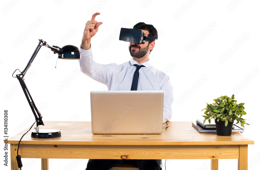 Businessman in his office using VR glasses holding something