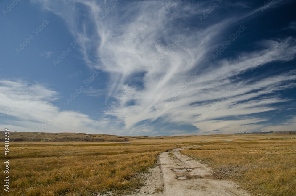 Wildlife Altai. The road, mountains and sky with clouds in summe Wildlife Altai. The road, mountains and sky with clouds in summe