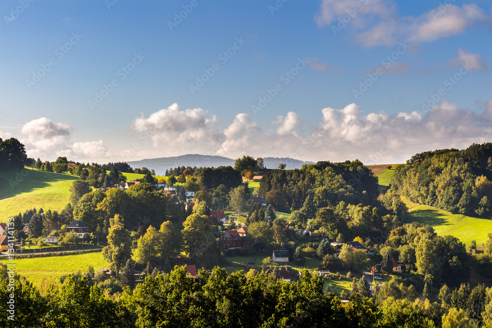 Saxon Switzerland (Bohemian Switzerland or Ceske Svycarsko) meadow and village on a sunny day in summer