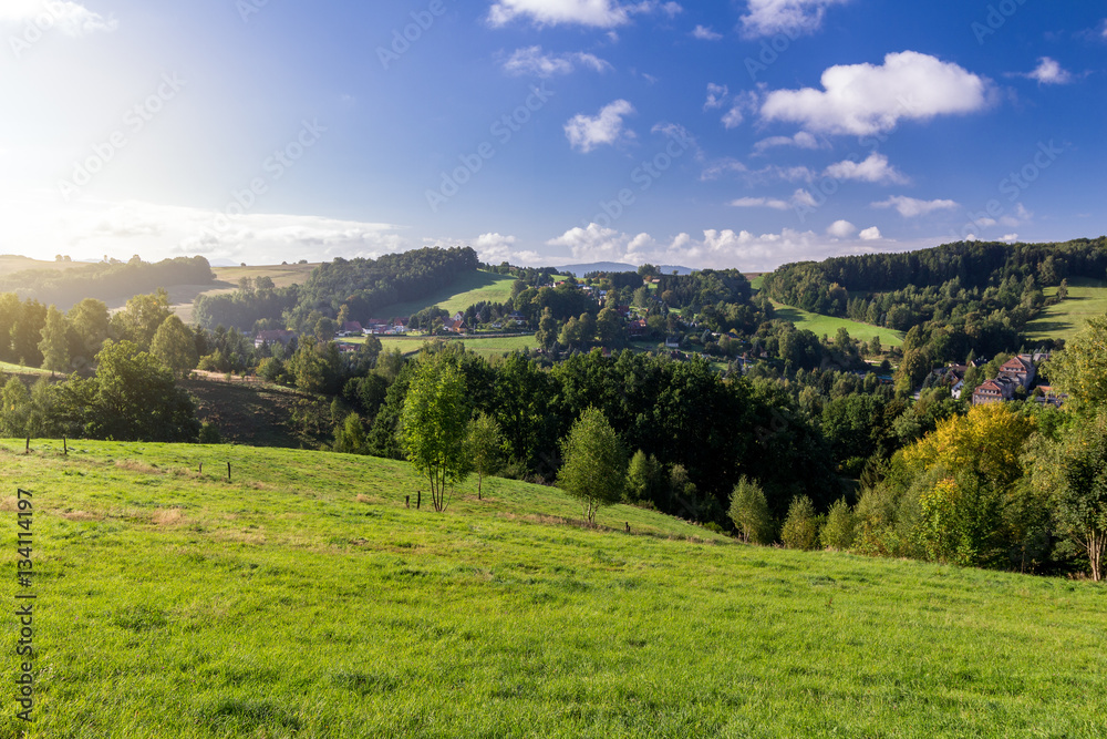 Saxon Switzerland (Bohemian Switzerland or Ceske Svycarsko) meadow and village on a sunny day in summer