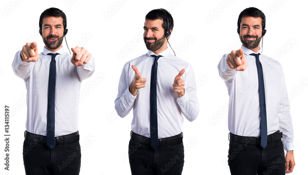 Young man with a headset pointing to the front Young man with a headset pointing to the front
