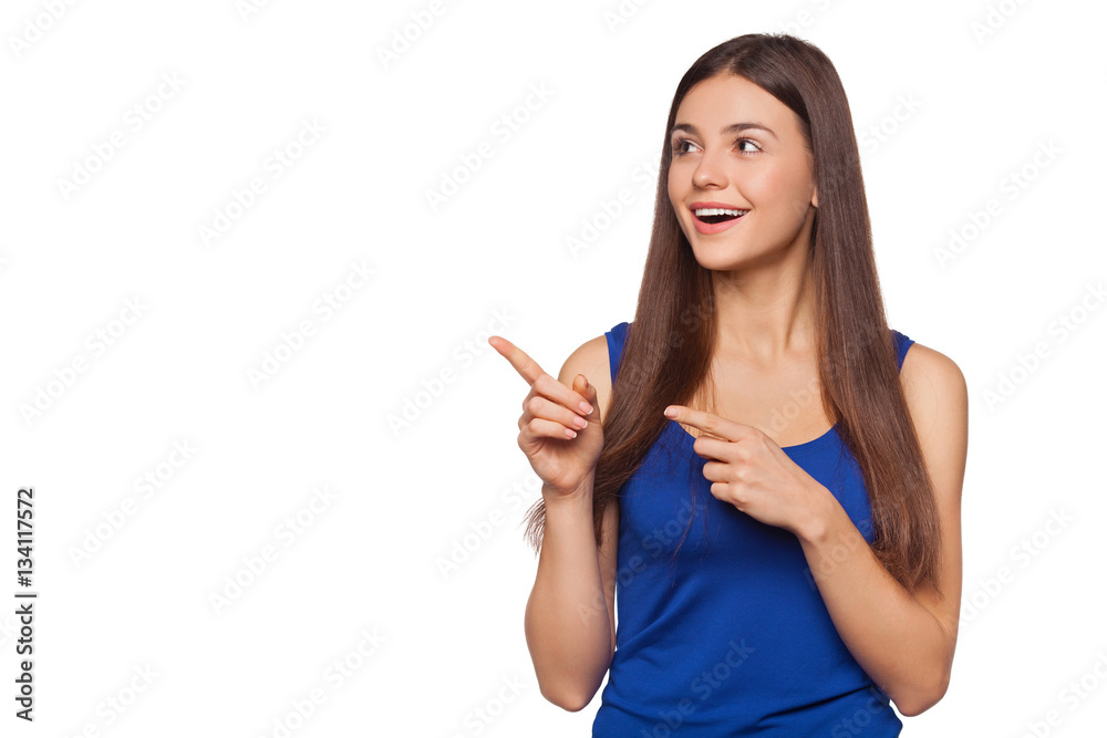 Smiling excited woman showing finger on copy space for product or text, isolated over white background Smiling excited woman showing finger on copy space for product or text, isolated over white background