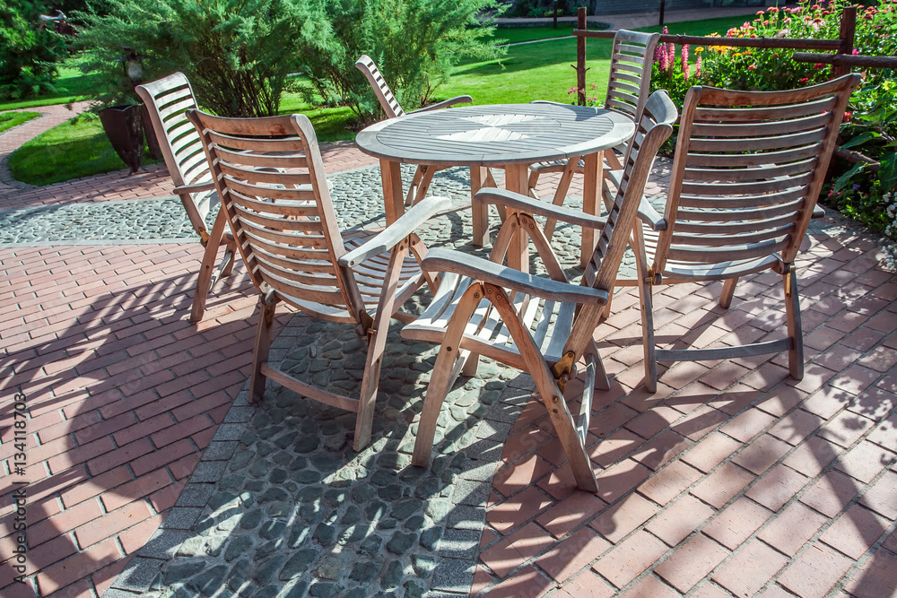 Chairs and glass table on brick terrace at countryside

