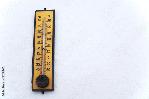 old thermometer on white snow background