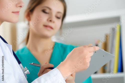 Two female medicine doctors working at their office