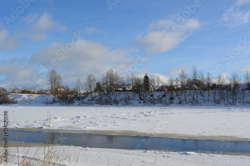 beautiful winter landscape: a city in the distance, blue sky, river and snow, nature 