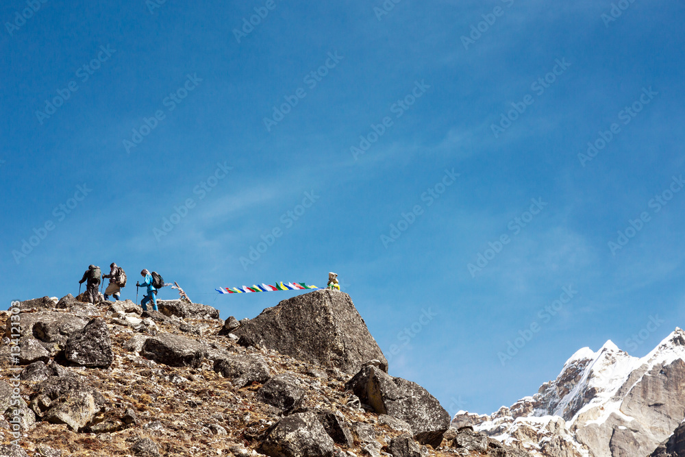 Fototapeta premium Mountain Peak with buddhist prayer Flags and Climbers walking