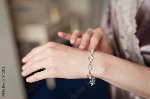 Bride's hands with simple manicure buttons bracelet © Olga Mishyna