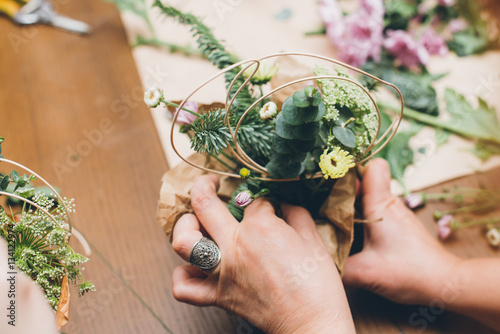 Fotografie Woman's hands making flower composition at floristic workshop, DIY tools, branches